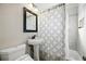 Clean bathroom featuring pedestal sink, framed mirror, and shower with decorative shower curtain at 1730 W 51St Ave, Denver, CO 80221