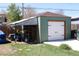 A detached garage featuring a large door, matching green exterior, and parking at 1730 W 51St Ave, Denver, CO 80221