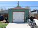 A detached garage featuring a large door, matching green exterior, and parking at 1730 W 51St Ave, Denver, CO 80221