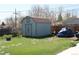 A backyard shed featuring barn doors and a charming cottage design with a roof that matches the house at 1730 W 51St Ave, Denver, CO 80221