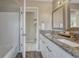 Bathroom features double sinks with granite countertops and white cabinets, complemented by gray walls and wood-look floors at 3689 Primrose Ln, Castle Rock, CO 80109