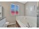Bathroom featuring a large soaking tub with white tile surround and neutral paint at 3689 Primrose Ln, Castle Rock, CO 80109
