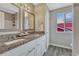 Bathroom features double sinks with granite countertop and white cabinets, complemented by gray walls and wood-look floors at 3689 Primrose Ln, Castle Rock, CO 80109