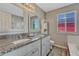 Bright bathroom featuring double vanity with granite countertop and wood-look floors at 3689 Primrose Ln, Castle Rock, CO 80109