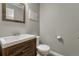 Neutral bathroom features a modern sink vanity, toilet, a decorative mirror, and wall decor at 3689 Primrose Ln, Castle Rock, CO 80109