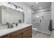 Modern bathroom featuring a double vanity, sleek mirror, and a glass-enclosed shower with tile surround at 21 Washington Ave, Golden, CO 80403