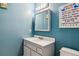 bathroom featuring blue walls, white vanity, and themed decor at 10474 W Purgatoire Peak, Littleton, CO 80127