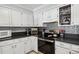 Kitchen features stainless steel appliances, sleek black countertops, and modern backsplash at 10474 W Purgatoire Peak, Littleton, CO 80127