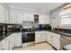 Well-lit kitchen featuring white cabinets, black countertops, and stainless steel appliances at 10474 W Purgatoire Peak, Littleton, CO 80127