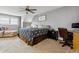 Spacious bedroom with a ceiling fan, a cozy chair, and neutral decor at 10474 W Purgatoire Peak, Littleton, CO 80127