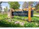 A wooden sign for The Ranch House with a stone base surrounded by greenery at 10474 W Purgatoire Peak, Littleton, CO 80127