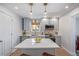 Bright kitchen with modern appliances, gray cabinets, an island with a white countertop, and updated lighting at 3050 N Marion St, Denver, CO 80205