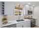 Modern kitchen features white cabinets, stainless steel appliances, light stone backsplash, and quartz countertops at 3050 N Marion St, Denver, CO 80205