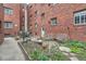 Outdoor patio area with seating, garden beds, and a brick facade, perfect for relaxing at 2115 E 14Th Ave # 8, Denver, CO 80206