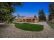 The sprawling backyard is perfect for entertaining with a patio and mature evergreens at dusk at 10525 W 18Th Ave, Lakewood, CO 80215