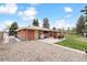 Backyard featuring a patio set, well-maintained lawn, and partial brick exterior with an open backyard at 10525 W 18Th Ave, Lakewood, CO 80215