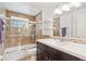 Tiled bathroom with updated fixtures, a glass-enclosed shower over tub, and modern vanity at 10525 W 18Th Ave, Lakewood, CO 80215