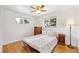 Cozy bedroom featuring hardwood floors, light-filled windows, and a comfortable bed with patterned bedding at 10525 W 18Th Ave, Lakewood, CO 80215