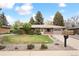 Charming single-story brick home with a well-manicured lawn and mature landscaping at 10525 W 18Th Ave, Lakewood, CO 80215