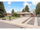 A charming single-story brick home featuring a well-kept front lawn with mature trees at 10525 W 18Th Ave, Lakewood, CO 80215