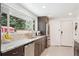 Modern kitchen featuring stone countertops, a stainless steel refrigerator, and a window overlooking the outdoors at 10525 W 18Th Ave, Lakewood, CO 80215