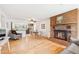 Bright, open-concept living area featuring hardwood floors and a charming brick fireplace at 10525 W 18Th Ave, Lakewood, CO 80215