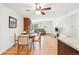 Open-concept living space featuring hardwood floors, a dining area, and a cozy living room with a brick fireplace at 10525 W 18Th Ave, Lakewood, CO 80215