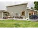 Expansive back patio with an outdoor dining area, seating, and a grill, ideal for entertaining at 8229 Cottongrass Ct, Castle Pines, CO 80108