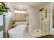 Modern bathroom with a freestanding tub, glass-enclosed shower, and neutral tiling at 8229 Cottongrass Ct, Castle Pines, CO 80108