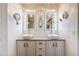 Bright bathroom featuring a double sink vanity, lighted mirrors, and modern fixtures at 8229 Cottongrass Ct, Castle Pines, CO 80108