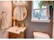 Stylish half-bathroom featuring a round mirror, modern vanity, and decorative fixtures at 8229 Cottongrass Ct, Castle Pines, CO 80108