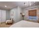 Bright bedroom with a cozy sitting area near the window and a decorative chandelier overhead at 8229 Cottongrass Ct, Castle Pines, CO 80108