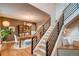 Inviting dining area with wooden table, hutch, and staircase with black railing at 8229 Cottongrass Ct, Castle Pines, CO 80108