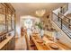 Dining room showcasing a wood table, chandelier, and open access to the living area and staircase at 8229 Cottongrass Ct, Castle Pines, CO 80108