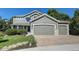 Charming two-story home featuring an attached three-car garage and beautifully landscaped front yard at 8229 Cottongrass Ct, Castle Pines, CO 80108
