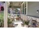 Inviting front porch with stone accents, comfortable seating, and decorative plants at 8229 Cottongrass Ct, Castle Pines, CO 80108