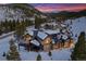 Stunning aerial view of a mountain home covered in snow with a dramatic sky at 444 Glen Eagle Loop, Breckenridge, CO 80424