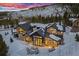 Mountain house aerial view reveals a snow-covered yard, patio, and large windows at 444 Glen Eagle Loop, Breckenridge, CO 80424