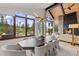 Dining area with mountain views, modern chandelier, fireplace, and open doors to an outdoor patio at 444 Glen Eagle Loop, Breckenridge, CO 80424