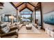 Bright living room with stone fireplace, hardwood floors, and sliding glass doors to outside view at 444 Glen Eagle Loop, Breckenridge, CO 80424