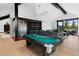 Spacious living room featuring a pool table, bar, modern lighting, and sliding doors leading to an outdoor deck at 444 Glen Eagle Loop, Breckenridge, CO 80424