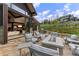 Outdoor patio with comfortable seating around a fire pit, grill, and views of the surrounding landscape at 444 Glen Eagle Loop, Breckenridge, CO 80424