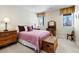 Tranquil bedroom with a lilac quilt, two windows, and classic wooden furnishings at 5329 Pinyon Jay Rd, Parker, CO 80134