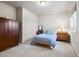 Well-lit bedroom featuring a bed with blue bedding, dark wood wardrobe, and ample space at 5329 Pinyon Jay Rd, Parker, CO 80134
