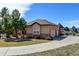 Charming home showcasing a blend of stucco and stone, complemented by a well-manicured lawn and a spacious driveway at 5329 Pinyon Jay Rd, Parker, CO 80134
