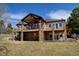 A two-story home boasts a covered deck, stone pillars and expansive windows offering scenic views and natural light at 5329 Pinyon Jay Rd, Parker, CO 80134