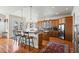 Well-appointed kitchen with a center island, breakfast bar, wood cabinets, and hardwood floors; an entertainer's dream at 5329 Pinyon Jay Rd, Parker, CO 80134