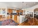 Open kitchen with an island, bar seating, wood cabinetry, and hardwood floors, perfect for entertaining and Gathering gatherings at 5329 Pinyon Jay Rd, Parker, CO 80134