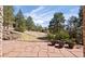 Beautiful backyard with stone patio, lush greenery, mature trees, and scenic views at 7370 S Catawba Way, Aurora, CO 80016