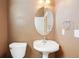 Powder room featuring a pedestal sink, designer mirror, and neutral walls to create a serene atmosphere at 7370 S Catawba Way, Aurora, CO 80016